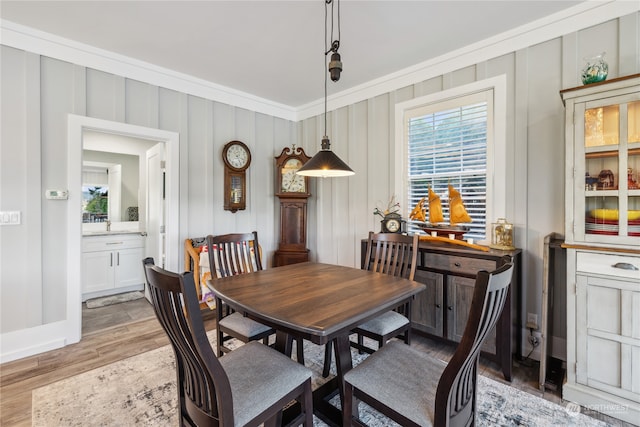 dining area featuring ornamental molding and light wood-type flooring