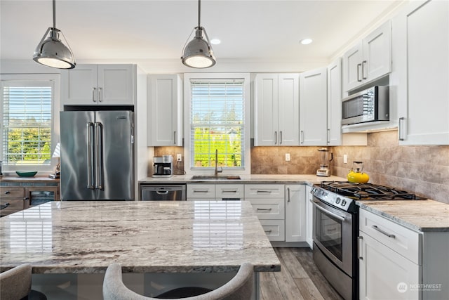 kitchen with white cabinets, stainless steel appliances, sink, and plenty of natural light