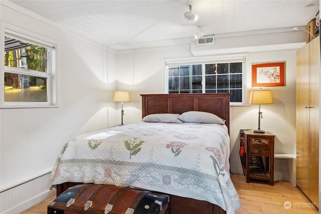 bedroom featuring light wood-type flooring and track lighting