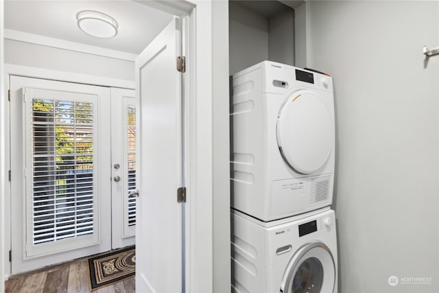 clothes washing area with stacked washer and clothes dryer and hardwood / wood-style floors