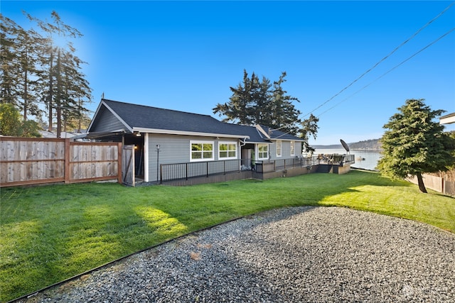 back of property with a yard and a water view