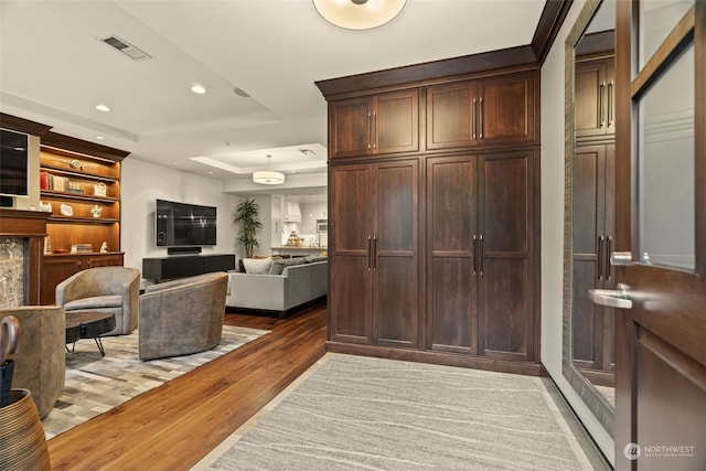 interior space featuring a tray ceiling and light hardwood / wood-style flooring