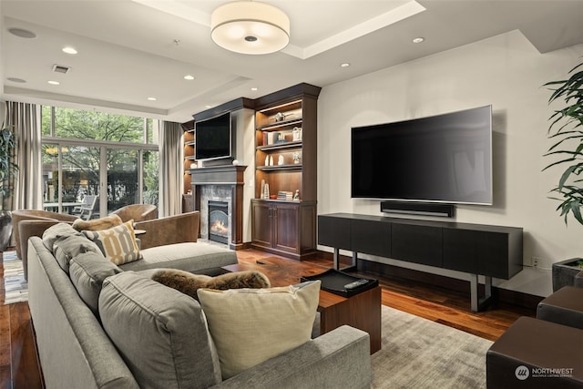 living room featuring hardwood / wood-style flooring and a tray ceiling