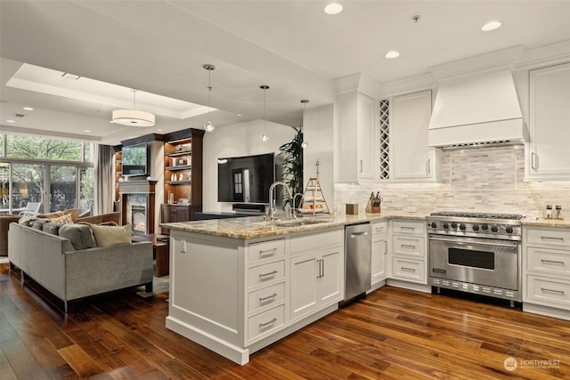 kitchen with white cabinetry, stainless steel appliances, kitchen peninsula, and premium range hood