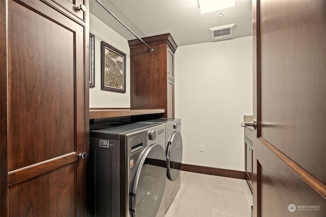 laundry room featuring cabinets, light tile patterned floors, and independent washer and dryer