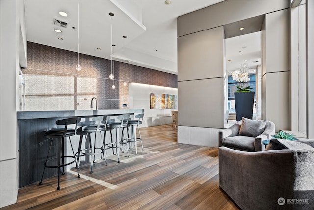 kitchen with hardwood / wood-style flooring, a breakfast bar, and sink