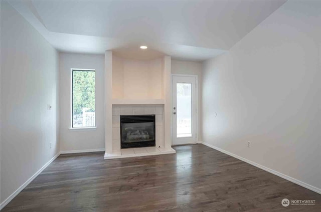 unfurnished living room featuring a fireplace and dark hardwood / wood-style floors