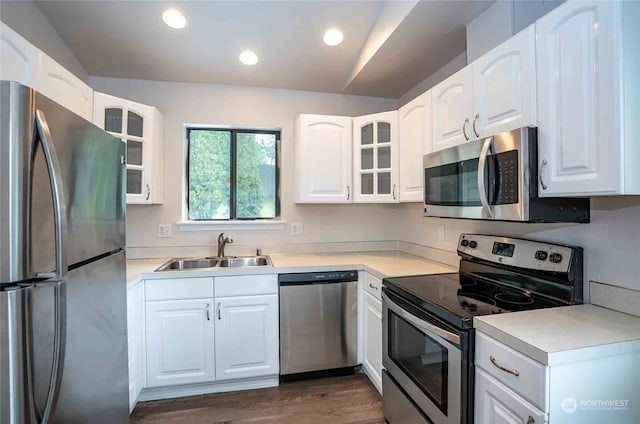 kitchen featuring lofted ceiling, dark wood-type flooring, sink, white cabinetry, and appliances with stainless steel finishes