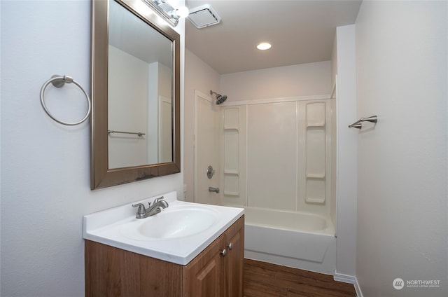 bathroom featuring vanity, hardwood / wood-style floors, and washtub / shower combination