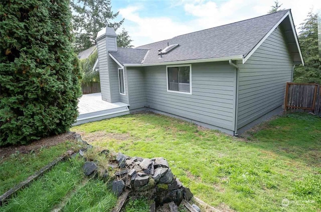 back of house with a wooden deck and a lawn