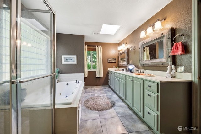 bathroom featuring a skylight, vanity, separate shower and tub, and tile patterned floors