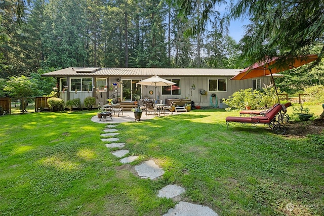 back of house featuring a lawn and a patio