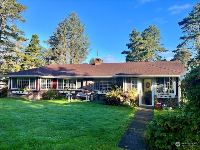 view of front of home featuring a chimney and a front lawn