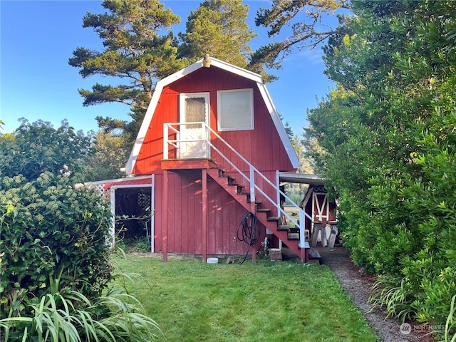 view of barn with a lawn and stairway