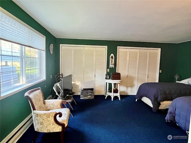 bedroom featuring carpet floors, two closets, and baseboard heating