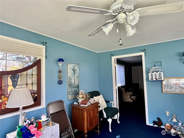 carpeted office space with ceiling fan and ornamental molding