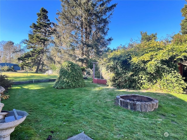view of yard with a fire pit and fence