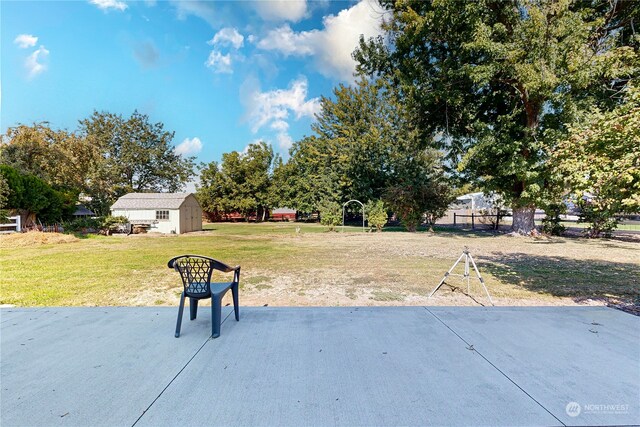 view of yard featuring a shed and a patio area