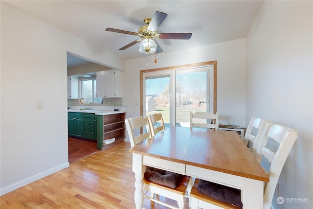 dining space with ceiling fan and light hardwood / wood-style floors