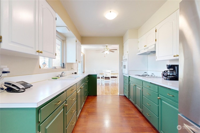 kitchen featuring sink, hardwood / wood-style floors, white cabinets, and ceiling fan