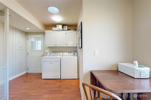 washroom with cabinets, washer and dryer, and light wood-type flooring