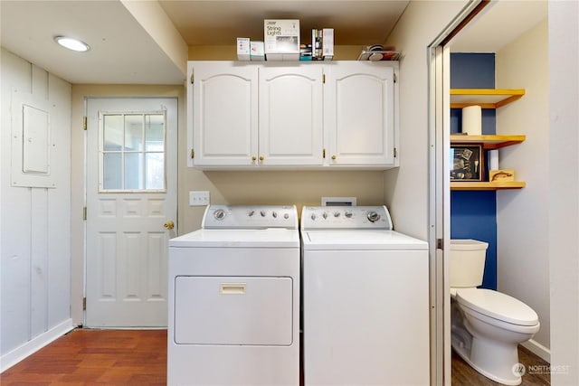 laundry room featuring hardwood / wood-style floors, washing machine and clothes dryer, and electric panel