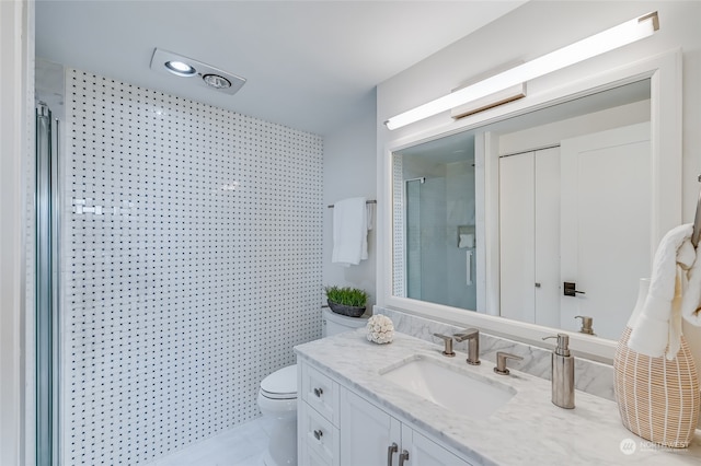 bathroom featuring vanity, a shower with shower door, toilet, and tile patterned flooring