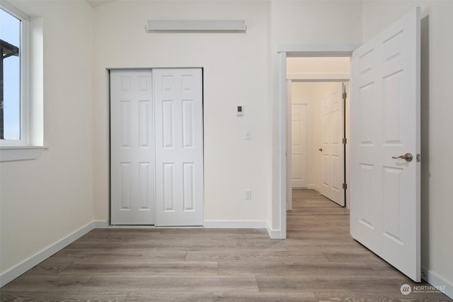 unfurnished bedroom with a closet and light hardwood / wood-style flooring