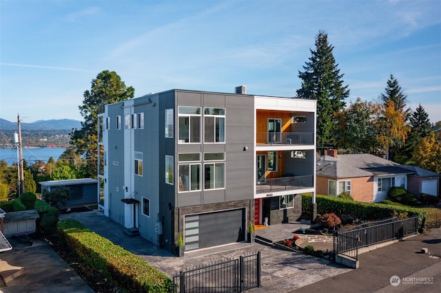 contemporary home featuring a balcony, a mountain view, and a garage