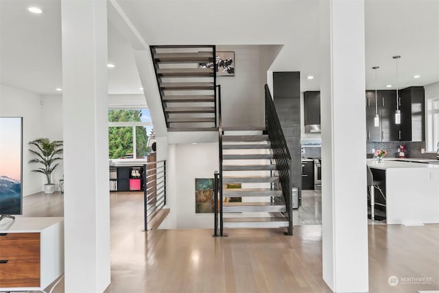 stairway featuring recessed lighting and wood finished floors