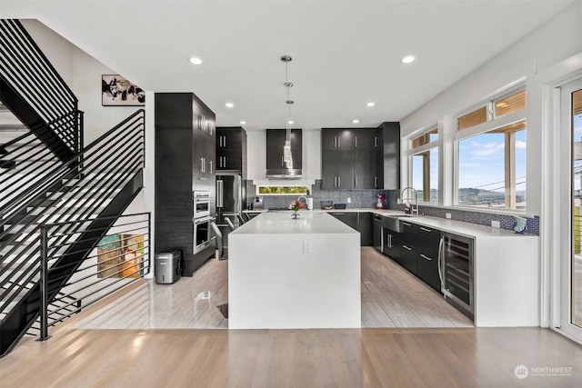 kitchen with extractor fan, light countertops, dark cabinetry, and wine cooler