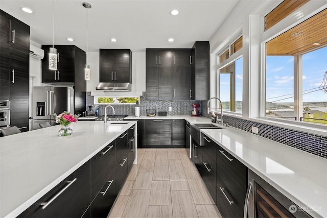 kitchen with light countertops, a sink, modern cabinets, and dark cabinets