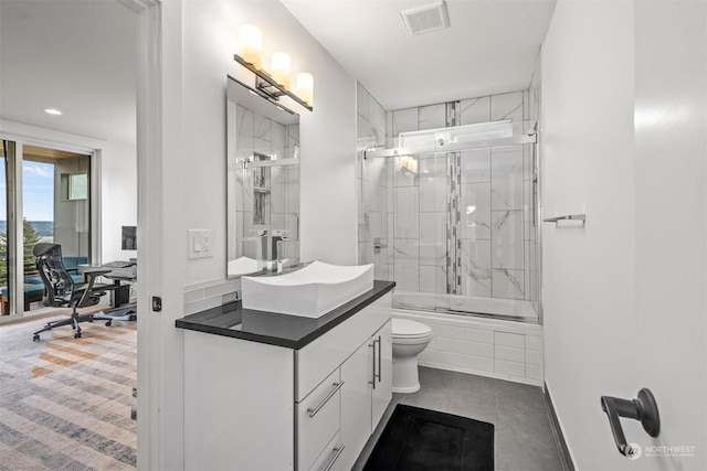 bathroom featuring visible vents, toilet, vanity, shower / bath combination with glass door, and tile patterned floors