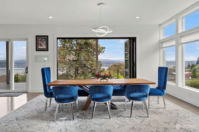 dining space featuring baseboards, recessed lighting, a notable chandelier, and wood finished floors