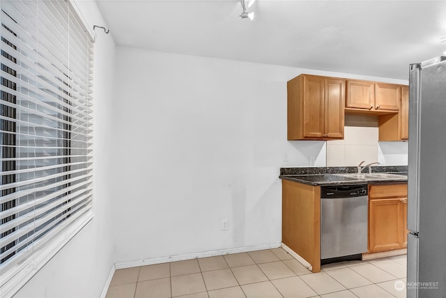 kitchen with stainless steel appliances, sink, and light tile patterned floors