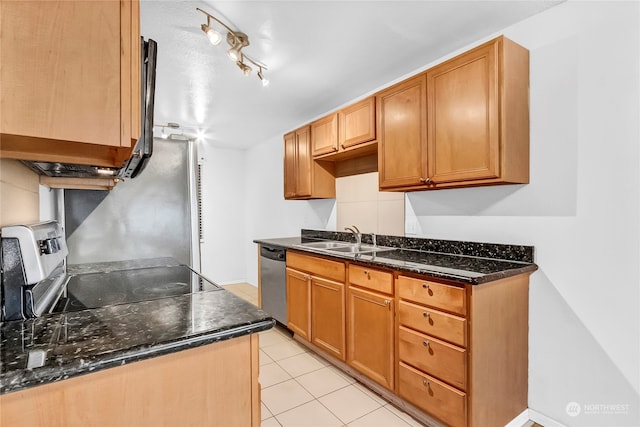 kitchen with stainless steel appliances, dark stone countertops, sink, and light tile patterned floors