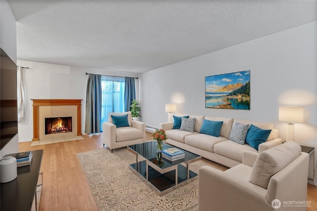 living room with a textured ceiling and light wood-type flooring