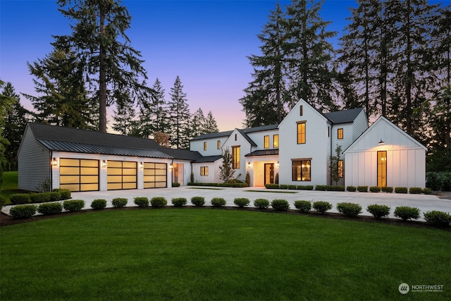 modern farmhouse style home featuring a garage and a yard