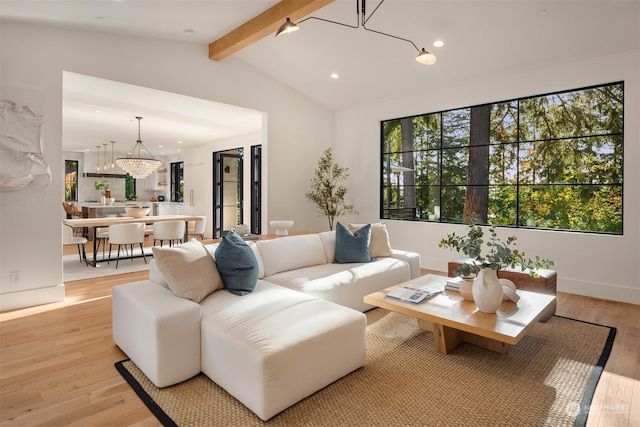 living room with light hardwood / wood-style floors, vaulted ceiling with beams, and a notable chandelier