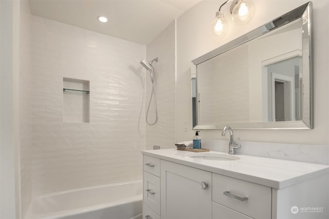 bathroom with tiled shower / bath combo and vanity