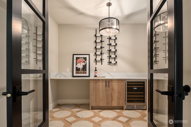 wine area with indoor bar, light tile patterned floors, and wine cooler