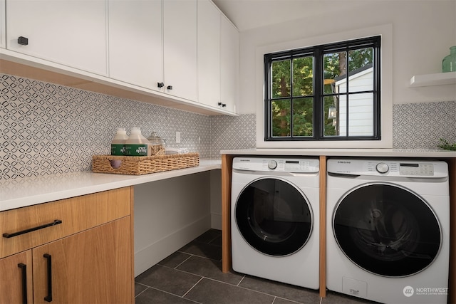 clothes washing area featuring dark tile patterned flooring, cabinets, and washer and clothes dryer