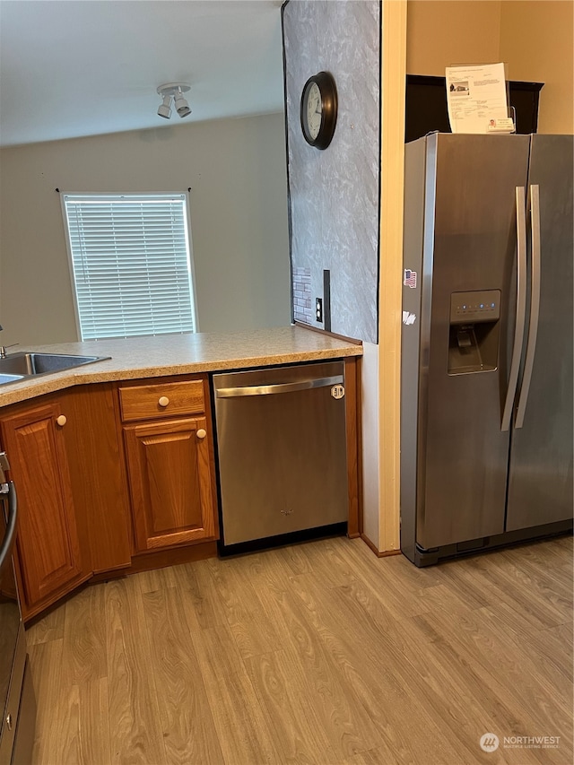 kitchen featuring sink, appliances with stainless steel finishes, and light hardwood / wood-style floors