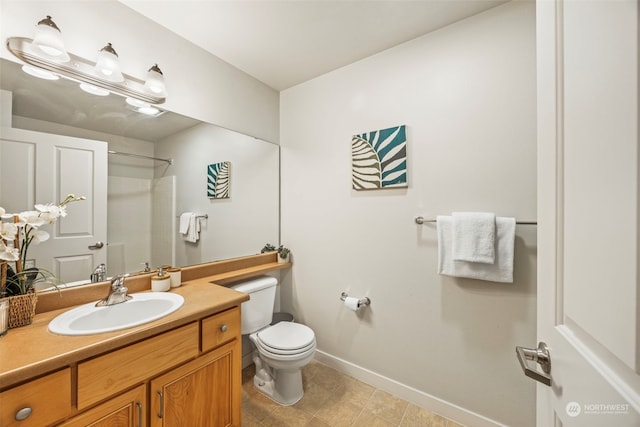 bathroom featuring vanity, tile patterned floors, toilet, and walk in shower