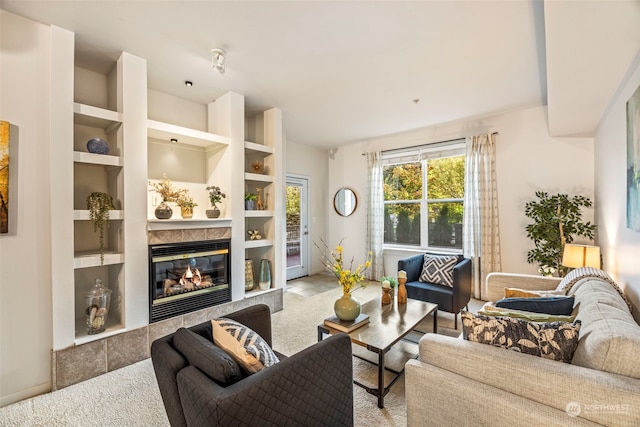 carpeted living room with a fireplace and built in shelves