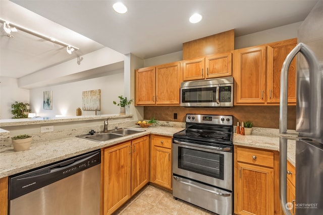 kitchen featuring light stone countertops, light tile patterned flooring, appliances with stainless steel finishes, and sink