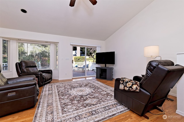 living room with ceiling fan, high vaulted ceiling, plenty of natural light, and light hardwood / wood-style floors