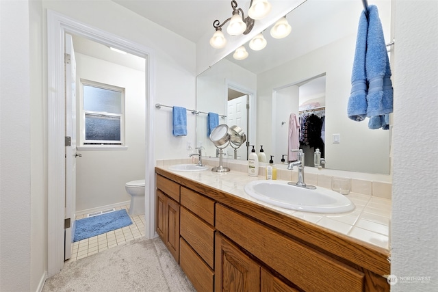 bathroom featuring tile patterned flooring, vanity, and toilet