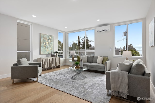 living room with light hardwood / wood-style floors and a wall unit AC