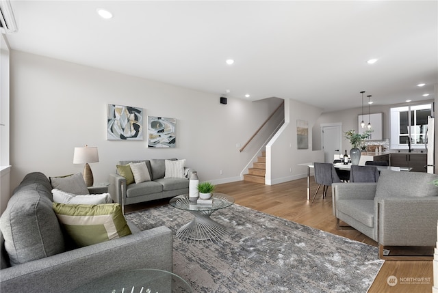 living room featuring an AC wall unit and wood-type flooring